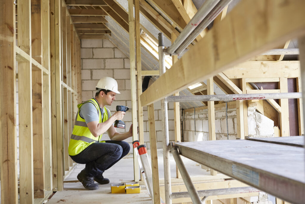 Picture of a tradesperson working on an house with a drill