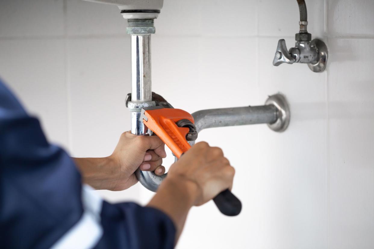 plumber at work in a bathroom, plumbing repair service, assemble and install concept.