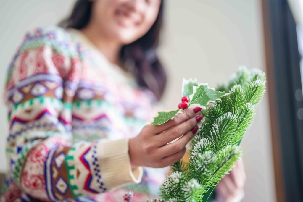 Picture of a woman holding a holiday garland of dried eucalyptus